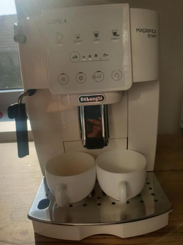 a coffee maker with two bowls on a stand at Apartman Diana in Boldogkőváralja