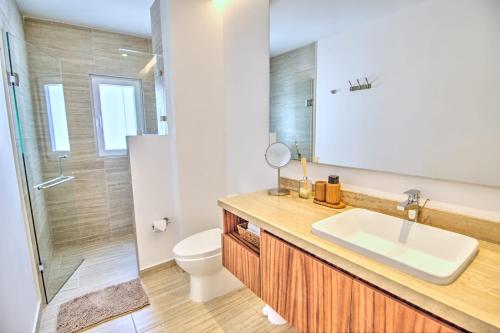 une salle de bain avec un lavabo, des toilettes et une douche dans l'établissement Casa Las Palmas - Condos by the Beach with Rooftop Pool, à Bucerías