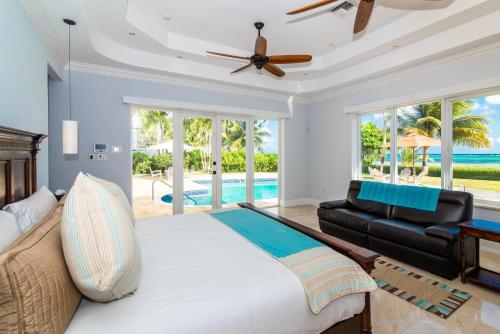 a bedroom with a bed and a couch and a ceiling fan at Faroway Luxury Villa in Half Way Pond