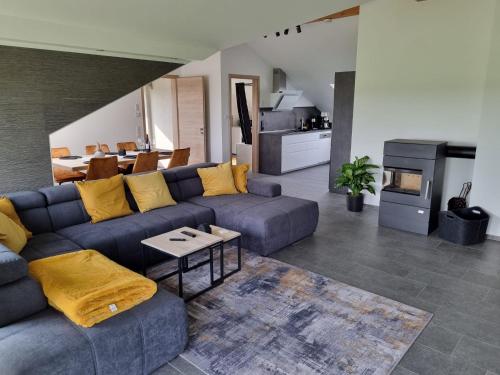 ein Wohnzimmer mit einem blauen Sofa und einem Tisch in der Unterkunft Ambiente Feriendomizil in Weilerswist