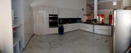 a kitchen with white cabinets and a marble floor at CABAÑA MANANTIAL DE DIOS in Turbo