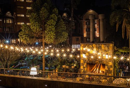 uma cerca com luzes em frente a um edifício em Hotel Recanto da Serra em Gramado