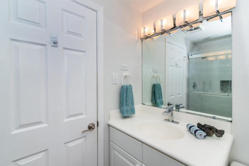 Baño blanco con lavabo y espejo en Georgetown Villas #201, en George Town