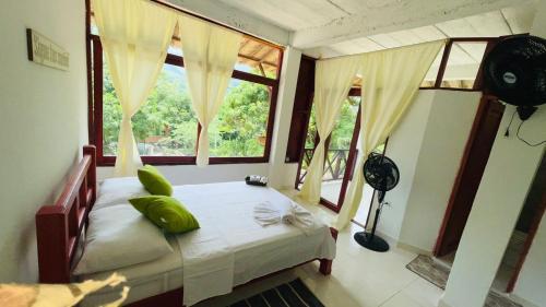 een slaapkamer met een bed en een groot raam bij Hotel talú tayrona in El Zaino