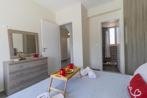 a bedroom with a bed and a dresser and a table at Enchanted Sunlit Villa Retreat 1 in Isthmia