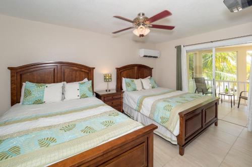 a bedroom with two beds and a ceiling fan at Island House #12 at Rum Point in Driftwood Village