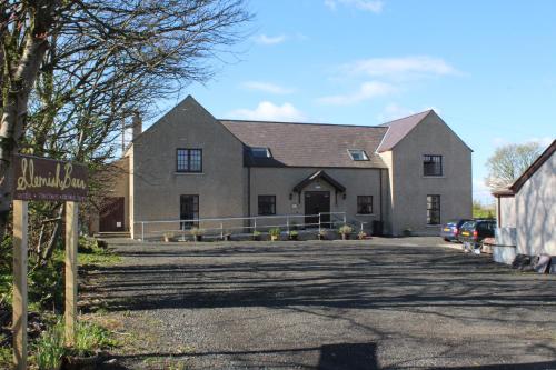 a large house with a sign in front of it at Slemish Barn Hostel in Ballymena
