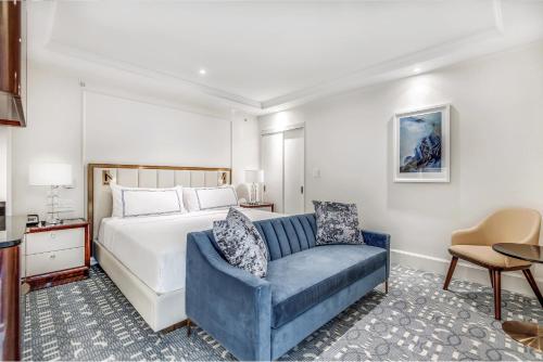 a bedroom with a bed and a blue chair at AZUR Legacy Collection Hotel in Vancouver