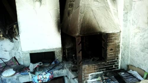 a brick fireplace in a dirty room with debris at Nireas in Nea Skioni