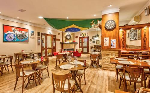 a restaurant with tables and chairs in a room at Hotel Recanto da Serra in Gramado