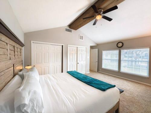 Schlafzimmer mit einem weißen Bett und einem Deckenventilator in der Unterkunft Tranquil Oasis in Houston
