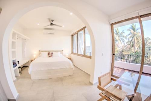 - une chambre avec un lit et un balcon dans l'établissement Estadios Suites - Only 3 Blocks to Beach, à Bucerías