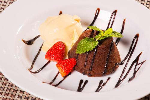 a plate with a piece of chocolate cake and strawberries at Hotel Recanto da Serra in Gramado