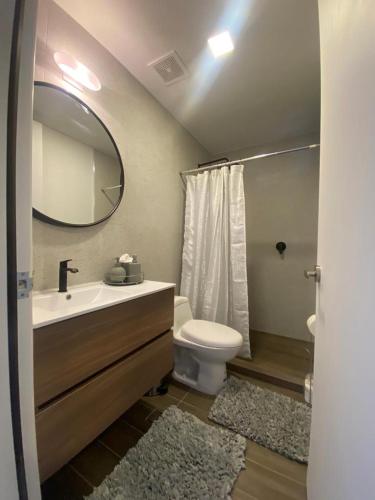 ein Badezimmer mit einem Waschbecken, einem WC und einem Spiegel in der Unterkunft CENTRICO TJ in Tijuana