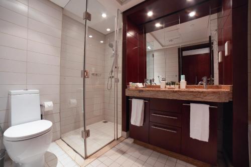 a bathroom with a toilet and a shower and a sink at Panoramic Burj Khalifa View Apt Downtown Dubai in Dubai