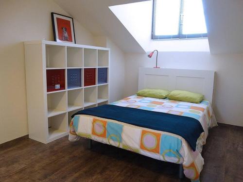 a bedroom with a bed and a book shelf at IAROS El Coto in Mogro