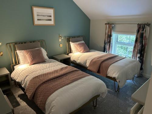 Irvinestown的住宿－Castle Irvine Estate，一间卧室设有两张床和窗户。