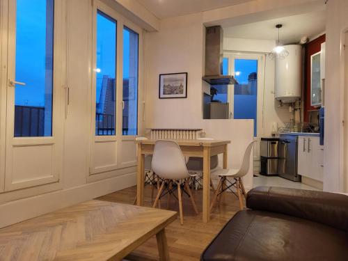 une cuisine et un salon avec une table et des chaises dans l'établissement le balcon d'Amiens, à Amiens