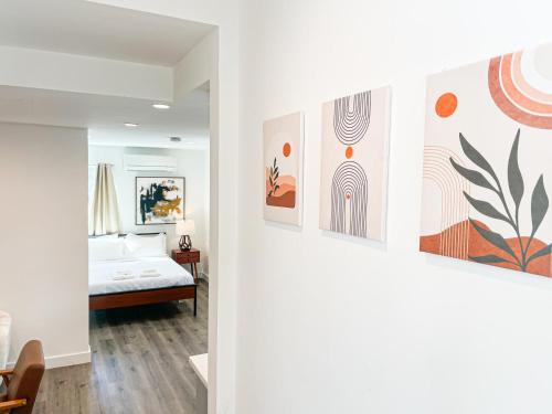 1 dormitorio con 1 cama y pinturas en la pared en Cozy Habitat, en Los Ángeles