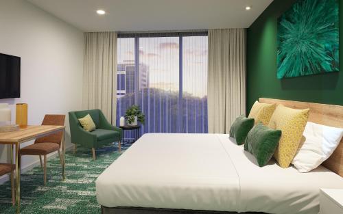 a hotel room with a bed and a table and a chair at La Quinta by Wyndham Ellerslie Auckland in Auckland
