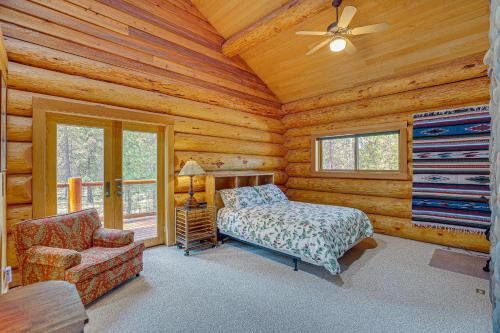 a bedroom with a bed and a chair in a log cabin at Bend Getaway with Private Hot Tub and Cozy Fireplace in Bend