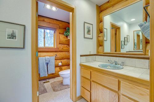 a bathroom with a sink and a toilet and a mirror at Bend Getaway with Cozy Fireplace in Bend