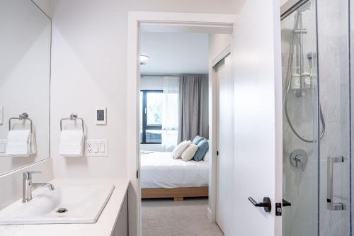 1 cama y baño con lavabo y ducha. en Western Star by Revelstoke Vacations, en Revelstoke