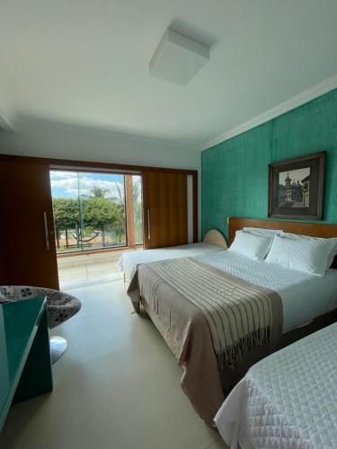 - une chambre avec 2 lits et une grande fenêtre dans l'établissement Village Recanto Splendory, à Prudente de Morais