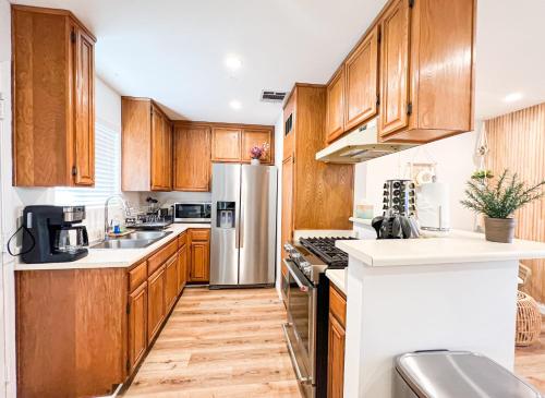 a kitchen with wooden cabinets and stainless steel appliances at Comfy 2-bedroom home in Hollywood in Los Angeles