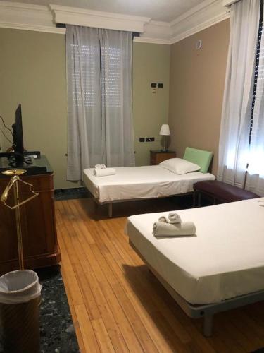 a room with two beds and a television in it at Villa Camilla Milano in Milan