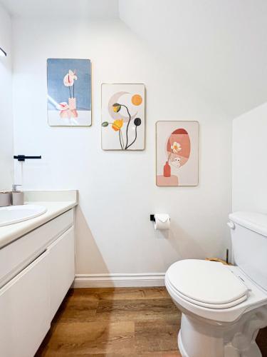 a bathroom with a toilet and three pictures on the wall at Comfy 2-bedroom home in Hollywood in Los Angeles