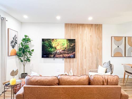 a living room with a couch and a tv on a wall at Comfy 2-bedroom home in Hollywood in Los Angeles