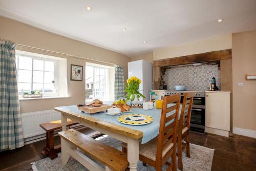 a kitchen with a wooden table with chairs and a dining room at East Ayrlow Banks in Hauxwell