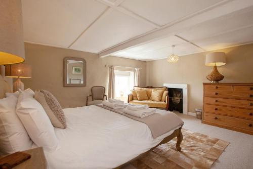 a bedroom with a large white bed and a fireplace at East Ayrlow Banks in Hauxwell