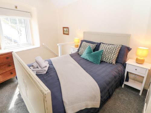 a bedroom with a large bed with pillows and a window at Rose Cottage in Castleton