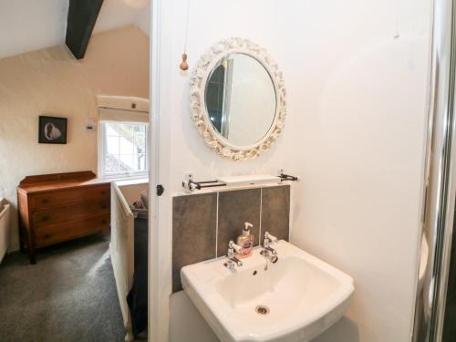 a bathroom with a sink and a mirror on the wall at Rose Cottage in Castleton