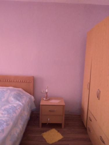 波格拉德茨的住宿－Relax apartament，一间卧室设有紫色的墙壁、一张床和一个床头柜。
