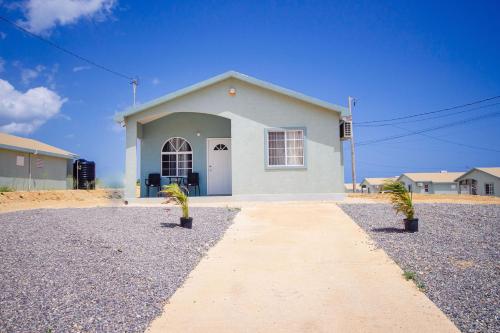 a white house with two plants in front of it at home with relaxing sea view in Discovery Bay