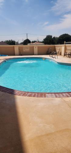 a large blue swimming pool in a building at Baymont by Wyndham Midland TX in Midland