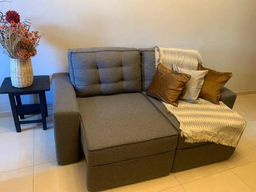 um sofá com almofadas e uma mesa com um vaso em Studio Lindo no coração de Picos em Picos