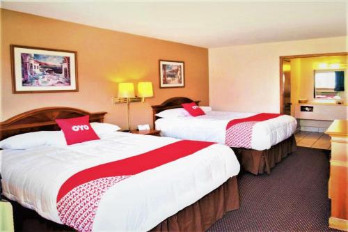 um quarto de hotel com duas camas com almofadas vermelhas em OYO Hotel Guymon OK US-54 em Guymon