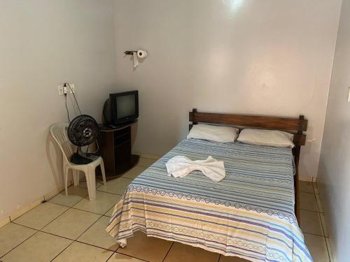 a bedroom with a bed and a tv at Hotel Cristo Redentor in Jataí