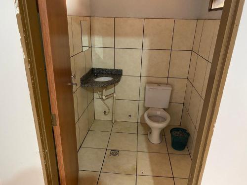 a small bathroom with a toilet and a sink at Hotel Cristo Redentor in Jataí