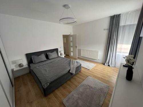 1 dormitorio con 1 cama en una habitación blanca en Ciki’s modern apartament, en Moşniţa Nouă