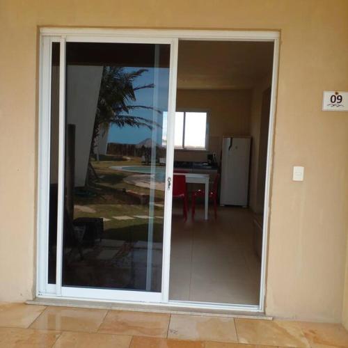 a sliding glass door in a room with a table at Vista do paraíso AP 09 Condomínio vilas na Praia Residente in Canoa Quebrada