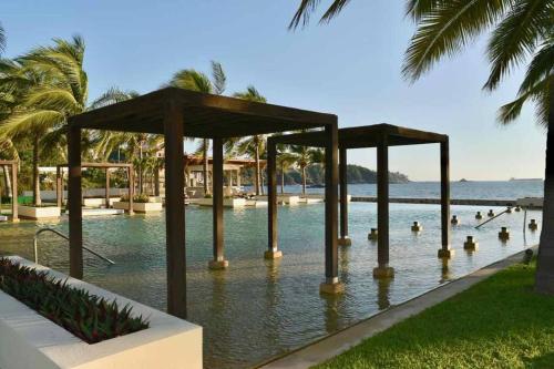 a swimming pool with people in the water at HERMOSO DEPARTAMENTO DE LUJO EN MANZANILLO A PIE DE PLAYA EN PONTO HORIZONTE MANZANILLO. PARA HASTA 8 PERSONAS, DE LO MEJOR DE MANZANILLO. HERMOSA VISTA AL MAR in Manzanillo