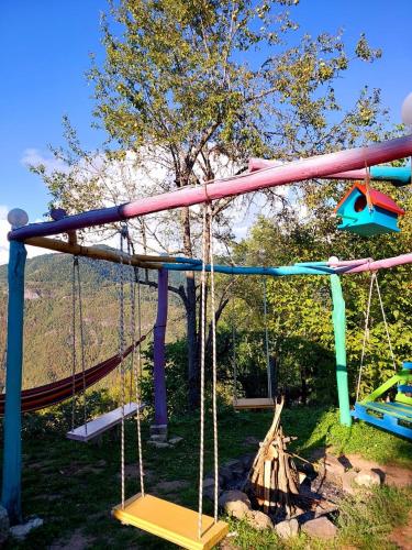 a playground with a slide and swings at Happy days house in Shuakhevi