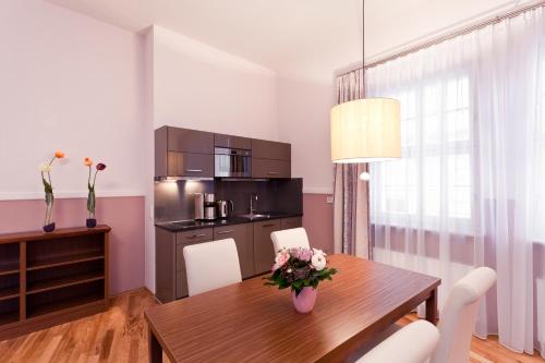 a kitchen and dining room with a wooden table and chairs at Aparthotel Am Schloss in Dresden