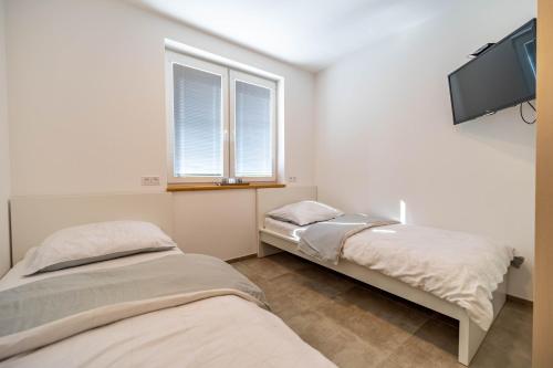 two beds in a room with a flat screen tv at Chata nad Milíkovem in Jablunkov