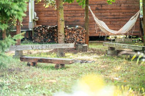 a hammock in a yard with a pile of wood at Chata louka in Plzeň